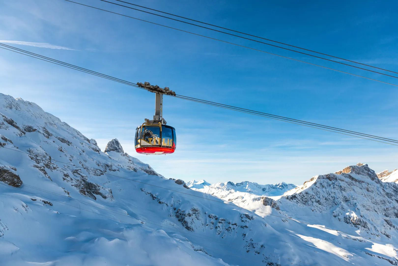 Le téléphérique Titlis Rotair survole un paysage de haute montagne alpine.